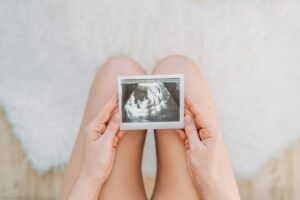 Pregnant woman looking at ultrasound scan of baby, close up of scan